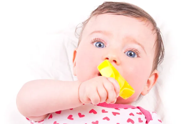 Baby girl with rattle teether toy. Royalty Free Stock Images