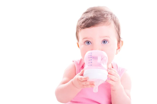 Menina bebê com garrafa de bebê rosa . — Fotografia de Stock