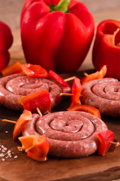 Raw sausage on wooden table. — Stock Photo, Image