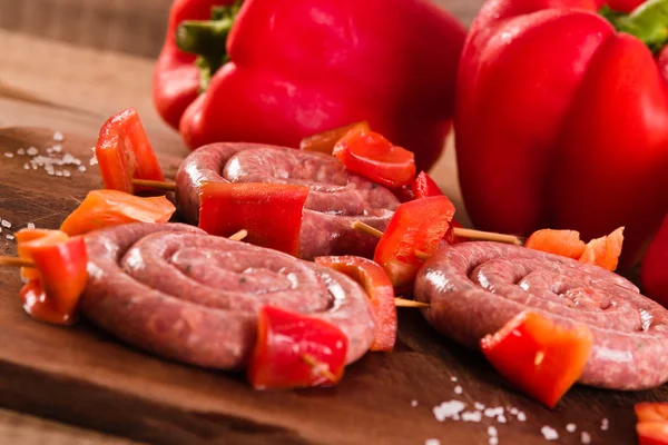 Raw sausage on wooden table. — Stock Photo, Image