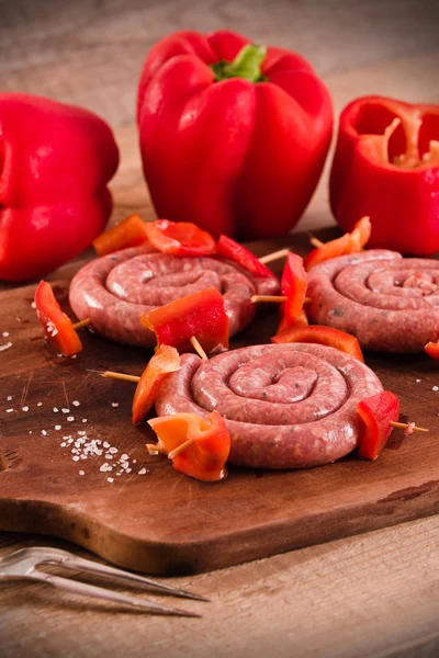 Raw sausage on wooden table. — Stock Photo, Image