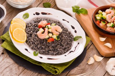 Beyaz tabakta sebzeli mürekkep balığı pilavı..