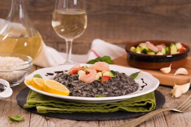 Beyaz tabakta sebzeli mürekkep balığı pilavı..