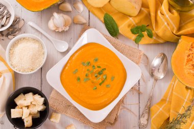 Beyaz tabakta patatesli balkabağı kremalı çorba.