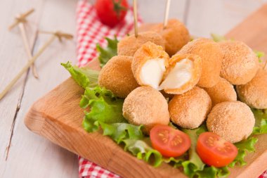 Kızarmış Mozzarella peynir topları kesme tahtasında.