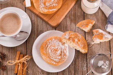 Beyaz tabakta krema kaplı tatlı hamur tatlısı.