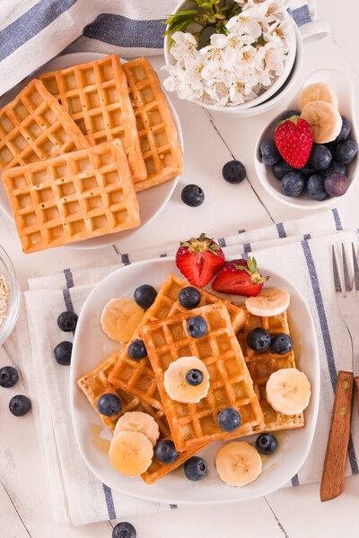 Waffles with blueberries, bananas and honey.