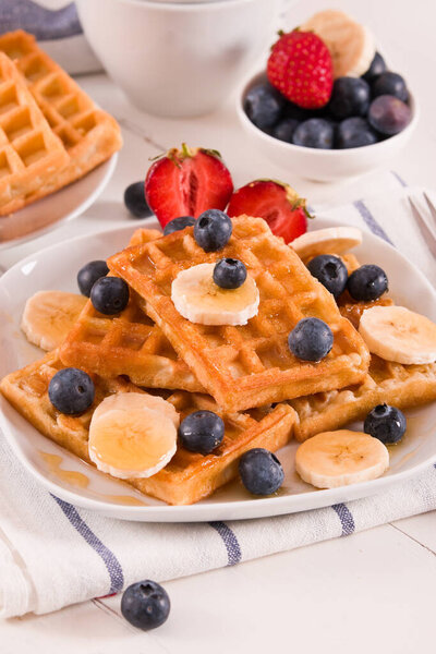 Waffles with blueberries, bananas and honey.
