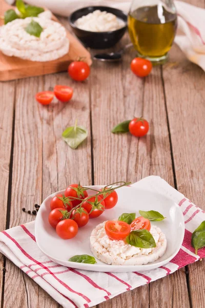 Rice cakes with milk flakes and tomato.