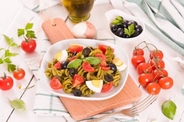 Fusilli pasta with cherry tomatoes, eggs and black olives.