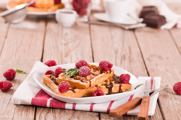 Waffles with raspberries and chocolate cream.