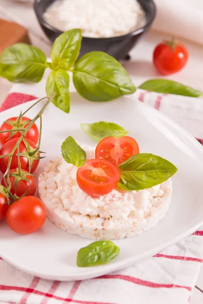 Rice cakes with milk flakes and tomato.