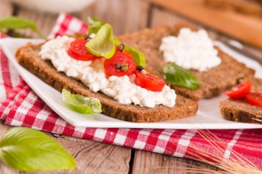 Çavdar ekmeği, süzme peynir, fesleğen ve domates..