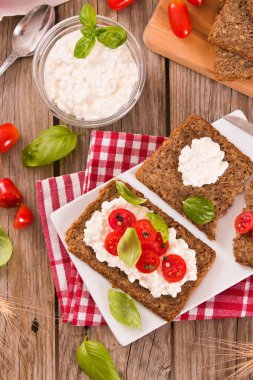 Çavdar ekmeği, süzme peynir, fesleğen ve domates..