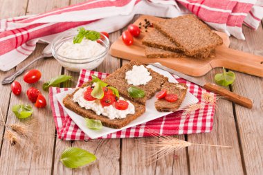 Çavdar ekmeği, süzme peynir, fesleğen ve domates..