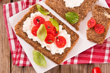 Çavdar ekmeği, süzme peynir, fesleğen ve domates..