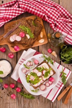 Çavdar ekmeği, süzme peynir, turp ve roka..