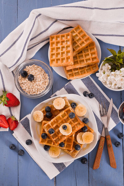 Waffles with blueberries, bananas and honey.