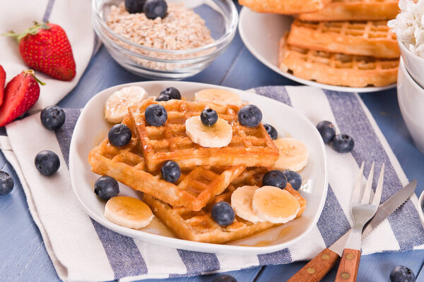 Waffles with blueberries, bananas and honey.