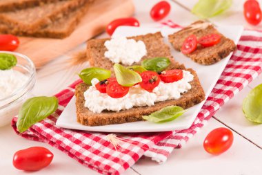 Çavdar ekmeği, süzme peynir, fesleğen ve domates..