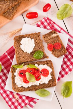Çavdar ekmeği, süzme peynir, fesleğen ve domates..