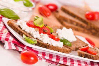 Çavdar ekmeği, süzme peynir, fesleğen ve domates..