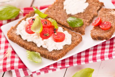 Çavdar ekmeği, süzme peynir, fesleğen ve domates..