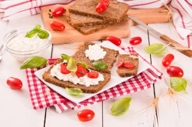 Çavdar ekmeği, süzme peynir, fesleğen ve domates..