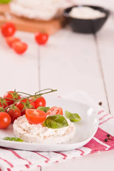 Rice cakes with milk flakes and tomato.