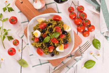 Fusilli pasta with cherry tomatoes, eggs and black olives.