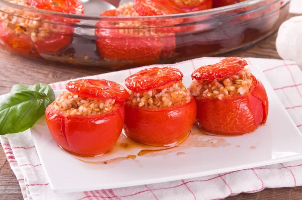 Stuffed tomatoes on a white plate.