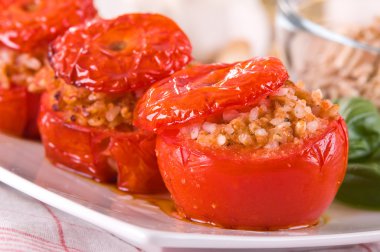 Doldurulmuş domatesler beyaz tabakta.