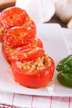 Doldurulmuş domatesler beyaz tabakta.