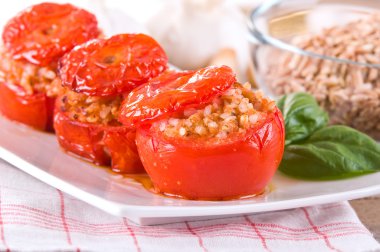 Doldurulmuş domatesler beyaz tabakta.