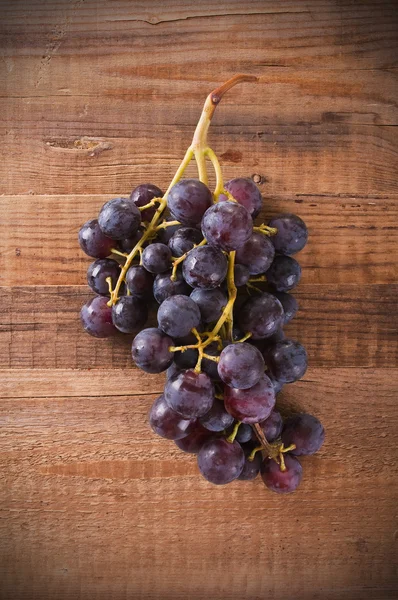 Afbeelding van een tros druiven op houten tafel — Stockfoto