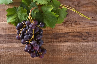 ahşap masa üstünde üzüm demet.