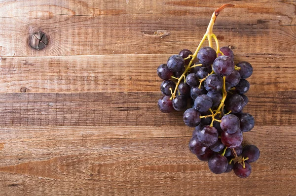 Tros druiven op houten tafel. — Stockfoto
