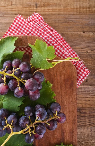 Afbeelding van een tros druiven op houten tafel. — Stockfoto