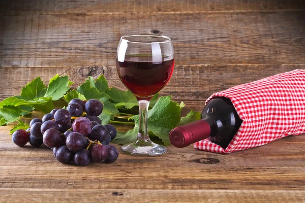 Ramo de uvas con botella y copa de vino tinto . —  Fotos de Stock