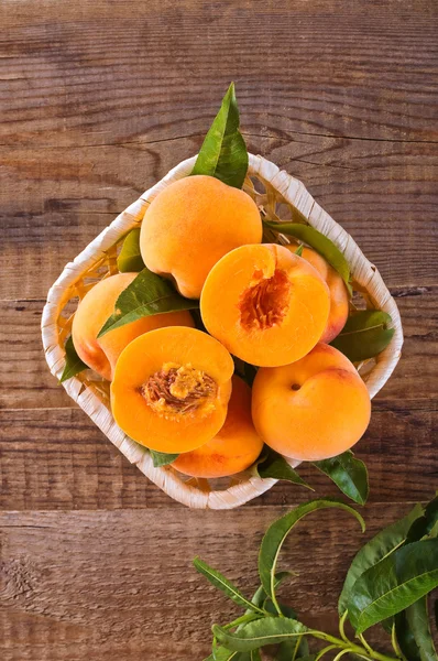 Peaches in the basket on wooden table. — Stock Photo, Image