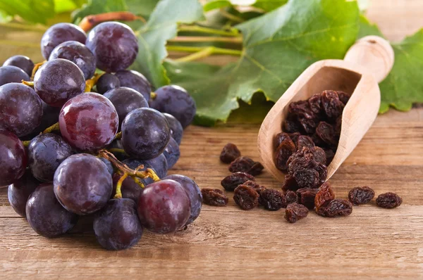 Druiven met rozijnen op houten tafel. — Stockfoto