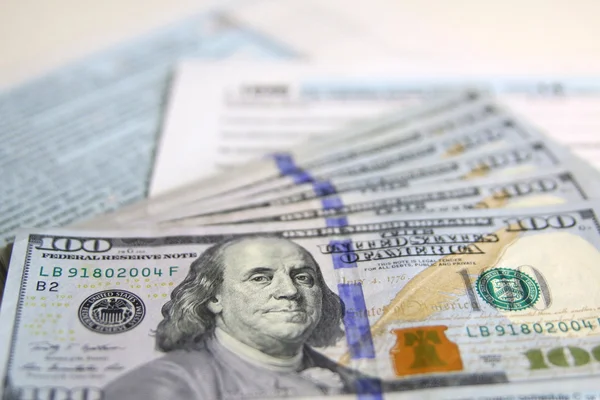 Formulaire fiscal 1040 des États-Unis avec de nouveaux billets de 100 dollars américains — Photo