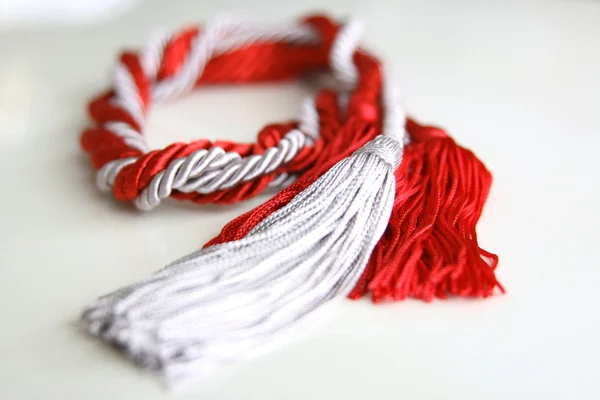 Corde grigie e rosse con nappa isolata — Foto Stock