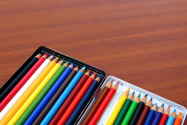 Crayons de couleur sur un fond de table en bois brun — Photo