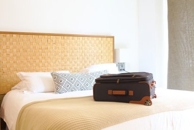 bavul içinde bir otel odasında yatağın üstüne