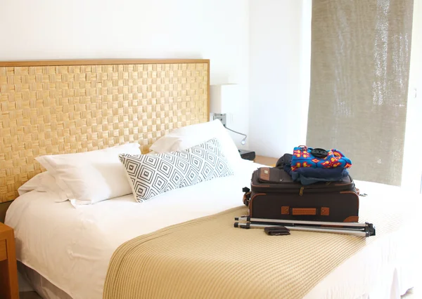 luggage on the white bed of a hotel