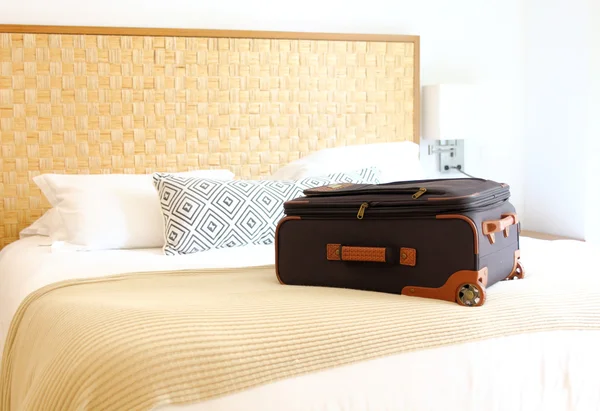 bavul içinde bir otel odasında yatağın üstüne