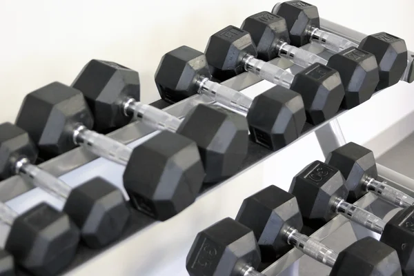 De nombreux haltères sont au stand à la salle de gym — Photo