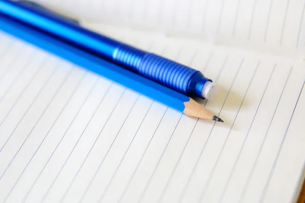 Drawing pencil and eraser over a white notebook — Stock Photo, Image