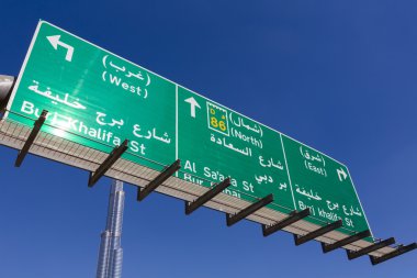 Dubai'de yön işareti ve berrak mavi gökyüzü ile Burç Halife
